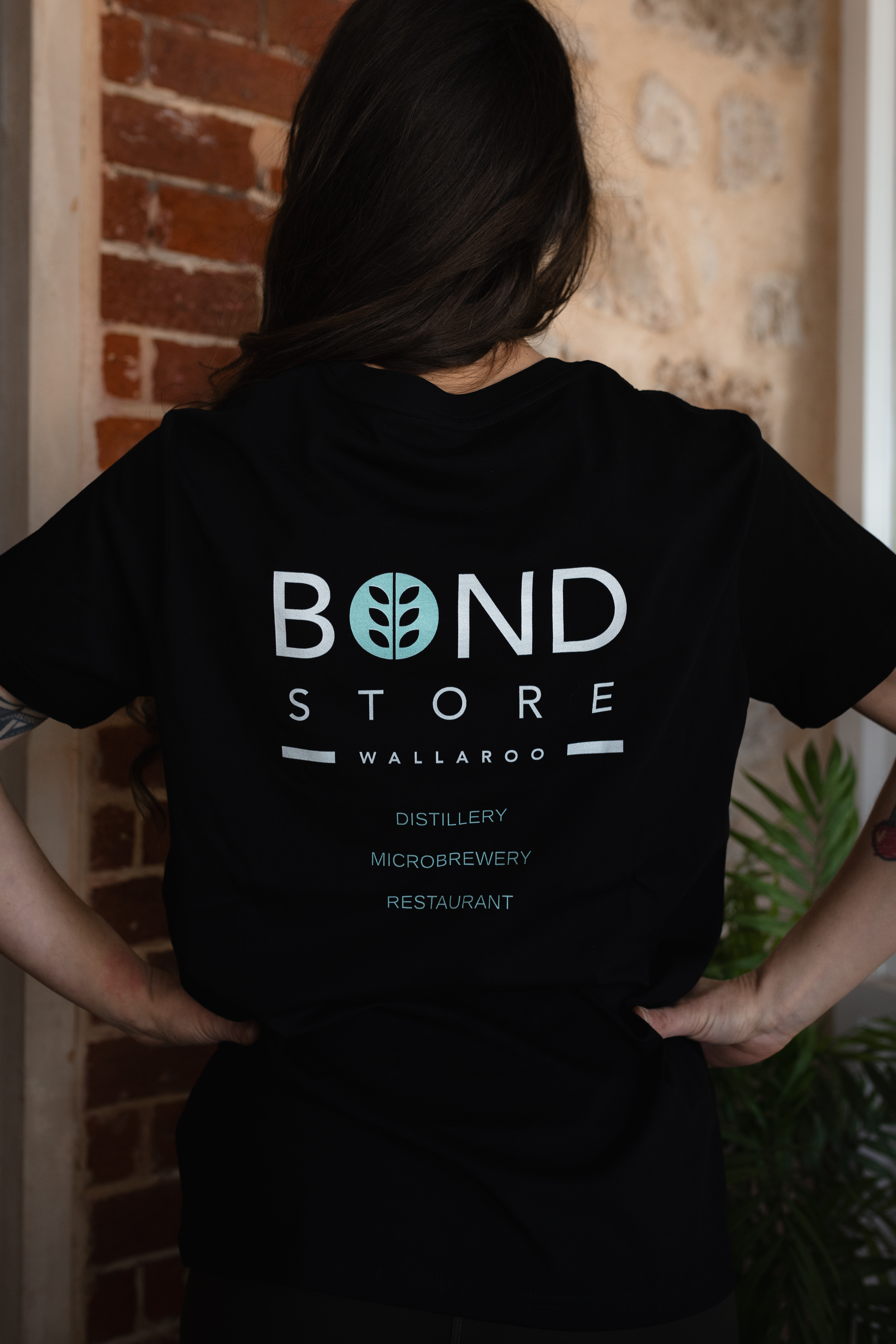 A person from the back wearing Bond Store T-shirt